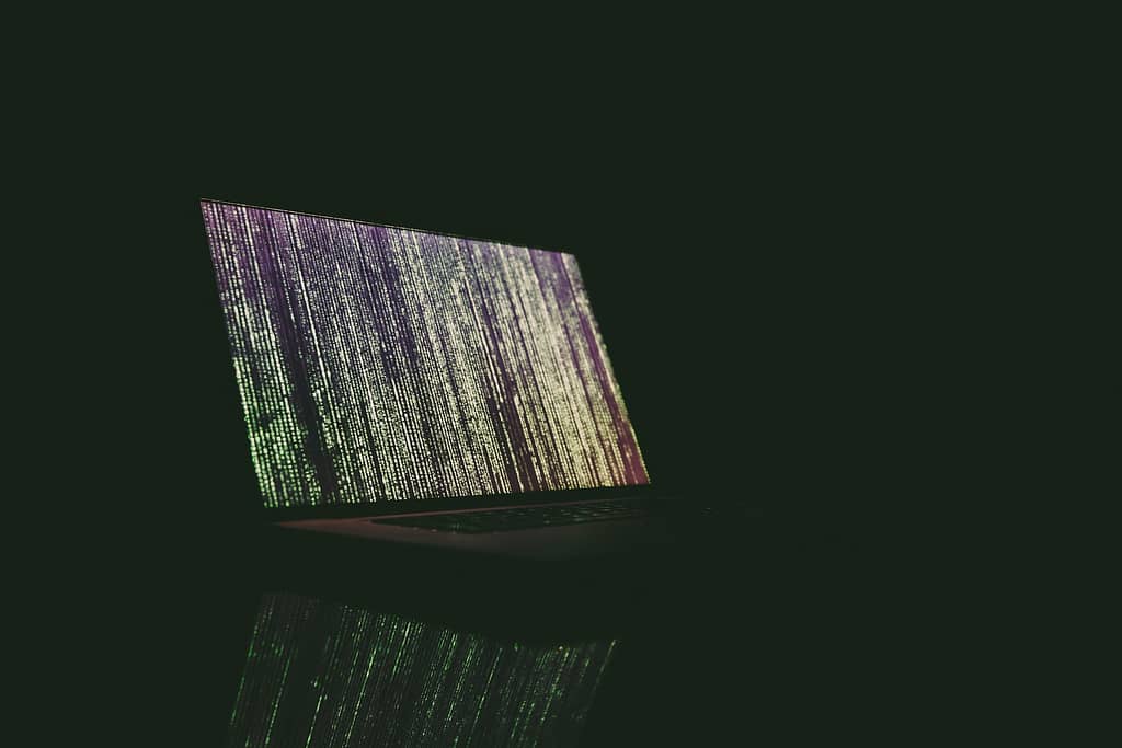 Dark laptop with green matrix-like content.