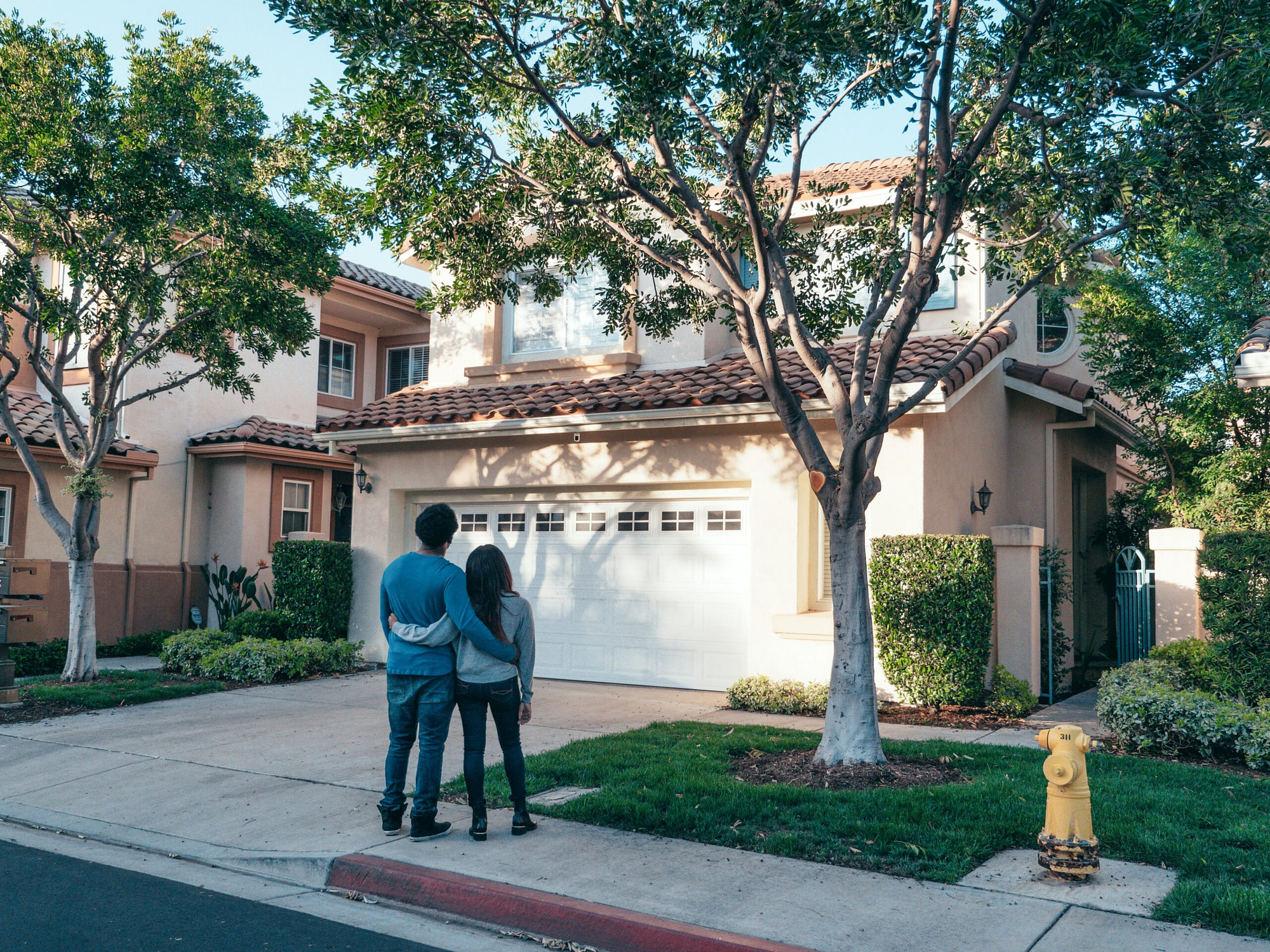 A couple standing in front of a house.