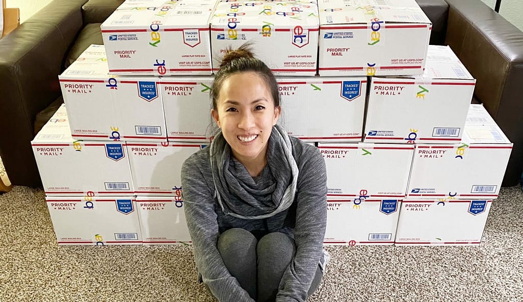 Becky sitting in front of boxes ready to be shipped.