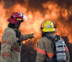 Two fire fighters look at a fire